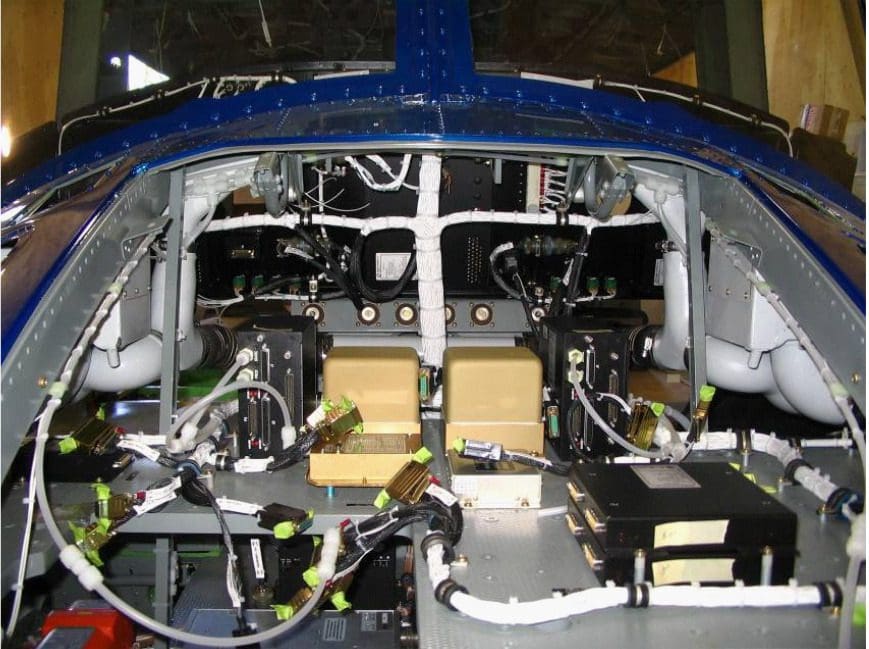 A blue airplane with wires and boxes on it.