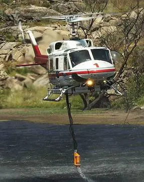 A Black Pipe Hanging From a Flying Helicopter