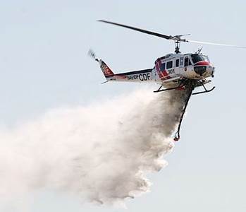 A Helicopter Flying in Air Spraying Fire Extinguisher