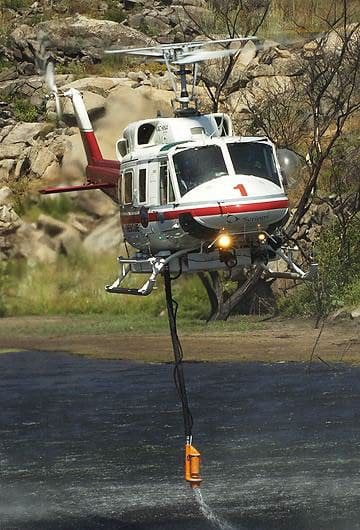 A helicopter is flying over the water.