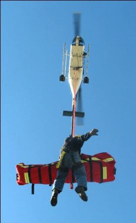 A man is flying a kite on the roof of a building.