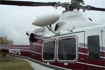 A helicopter with the door open on a cloudy day.